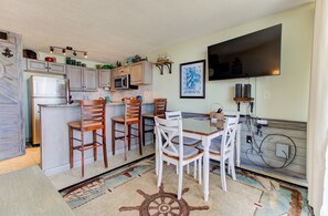 Enjoy cooking in this well-equipped kitchen with a central island, appliances, and a large flat-screen TV.