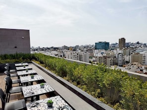 A rooftop terrace with outdoor seating and a city view.