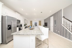 Enjoy cooking in this well-equipped kitchen with a central island, stainless steel appliances, and ample counter space.