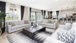 Ein geräumiger Wohnbereich mit zwei Sofas, einem Couchtisch und einer Küche im Hintergrund.