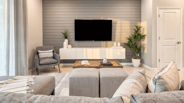 A living room with a flat-screen TV, grey upholstered sofa, a coffee table, and a potted plant. - Last Minute Disney Getaway! Townhouse with Private Pool. Book Now! #66503 (Orlando)