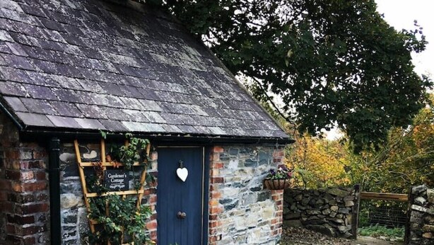 Un chalet rustique avec une porte bleue, une échelle en bois et un décor en forme de cœur.
