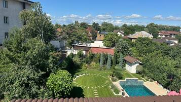 Un quartiere residenziale con piscina, prati verdi e diverse abitazioni.