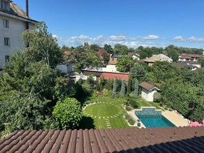 A residential area with a swimming pool, green lawns, and various houses.