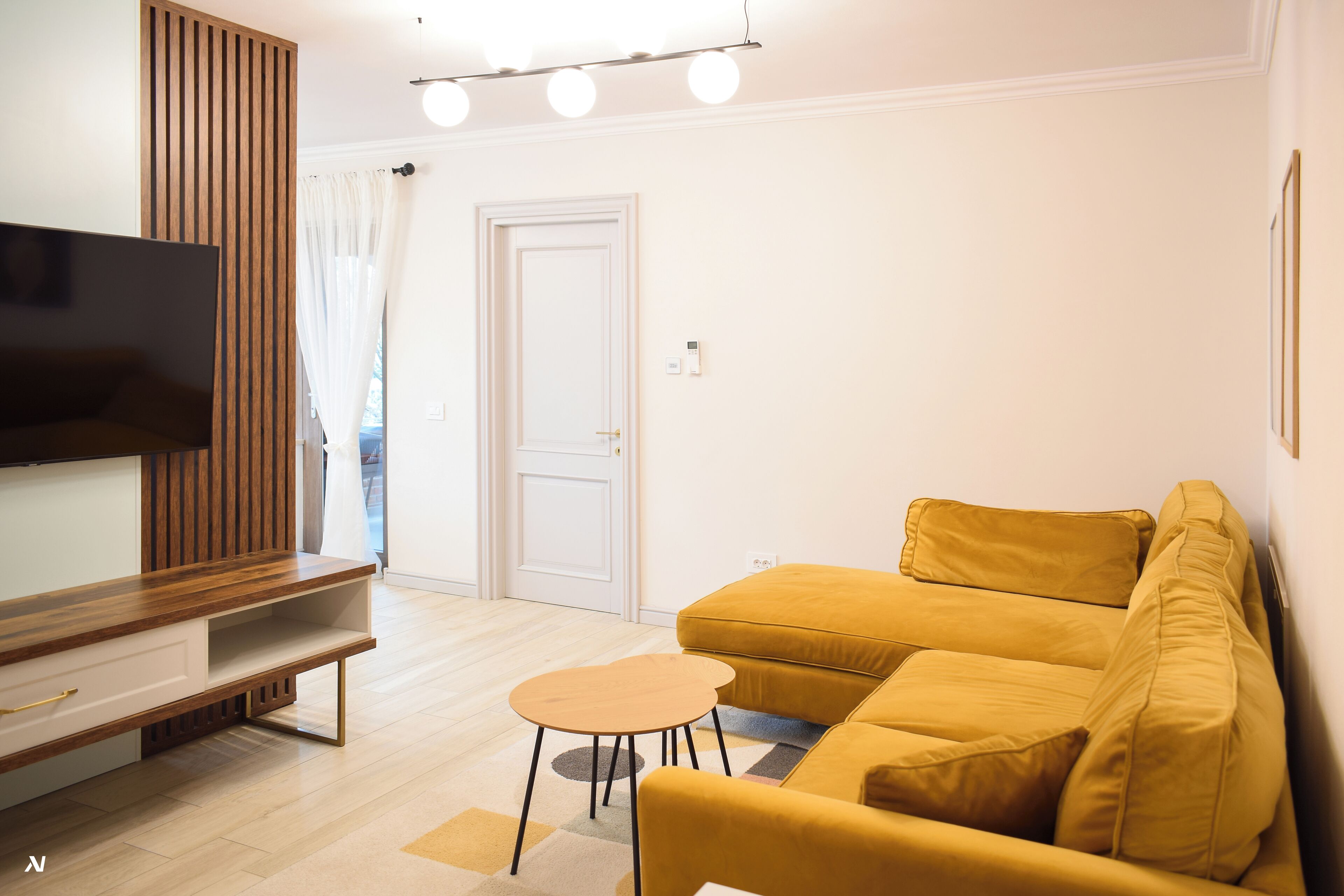 Un salon moderne avec un canapé, une table basse et un téléviseur.