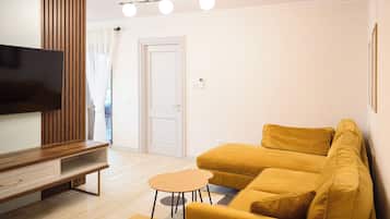 Un salon moderne avec un canapé, une table basse et un téléviseur.