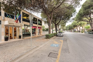 Hotel con escaparate, mesas al aire libre y aparcamiento, incluyendo plaza reservada para discapacitados.