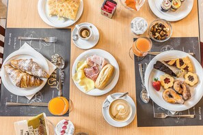 A breakfast buffet with various pastries, sandwiches, and beverages. - Villa Maria (Cesenatico)