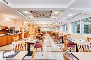 Un restaurante amplio con una barra larga, varias mesas y sillas.