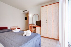 A hotel room with a bed, a desk, a chair, a wardrobe, and a mirror. - Villa Maria (Cesenatico)