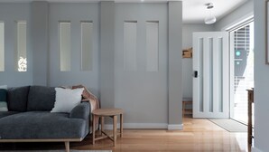Una sala moderna con un sofá gris, una mesita de madera y una alfombra gris.
