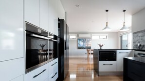 Una cocina moderna con armarios blancos, electrodomésticos de acero inoxidable y suelo de madera.
