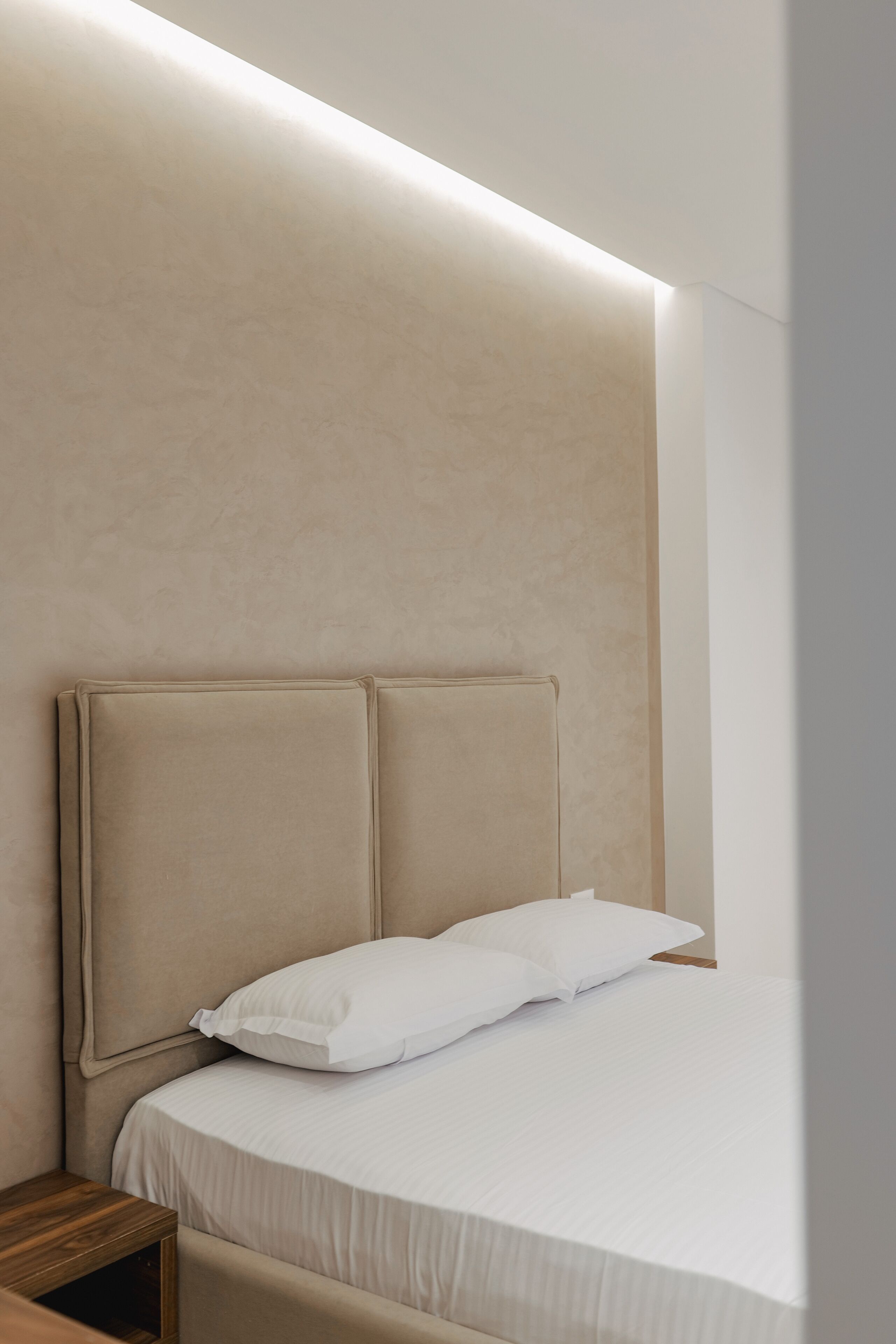 Une chambre à coucher avec un grand lit, une tête de lit et une table de chevet.