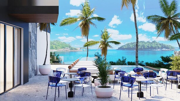 Un espace extérieur moderne, aménagé pour se détendre, avec vue sur la mer, agrémenté de palmiers et offrant un ciel dégagé.