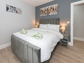 Relax in a stylish space with a large bed, bedside tables, and abstract artwork.