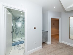 Experience a luxurious bathroom with a glass-enclosed shower and marble tiles.