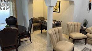 Ein Essbereich mit einem runden Tisch, Stühlen, einer Couch und einem Kicker.
