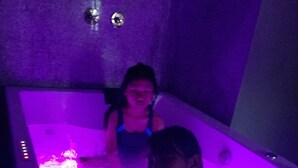 A person sitting in a bathtub with purple lighting. - Harrys Home  (Kathmandu)