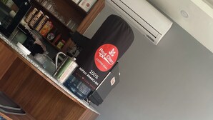 A coffee shop counter with a coffee machine, water bottles, and a Red Cherry branded coffee bag. - Harrys Home  (Kathmandu)