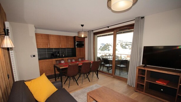 A modern living room with a sofa, a coffee table, a TV, and a dining area with a table and chairs. - 2nd floor, balcony, tv, 59m², Les Saisies (Hauteluce)