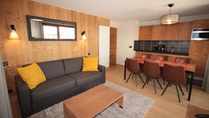 A modern living room with a sofa, coffee table, and dining area with chairs and a table. - 2nd floor, balcony, tv, 59m², Les Saisies (Hauteluce)
