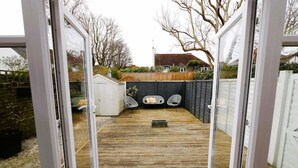 A wooden deck with a small shed and two chairs. - Trendy quirky ground floor Victorian garden flat (Worthing)