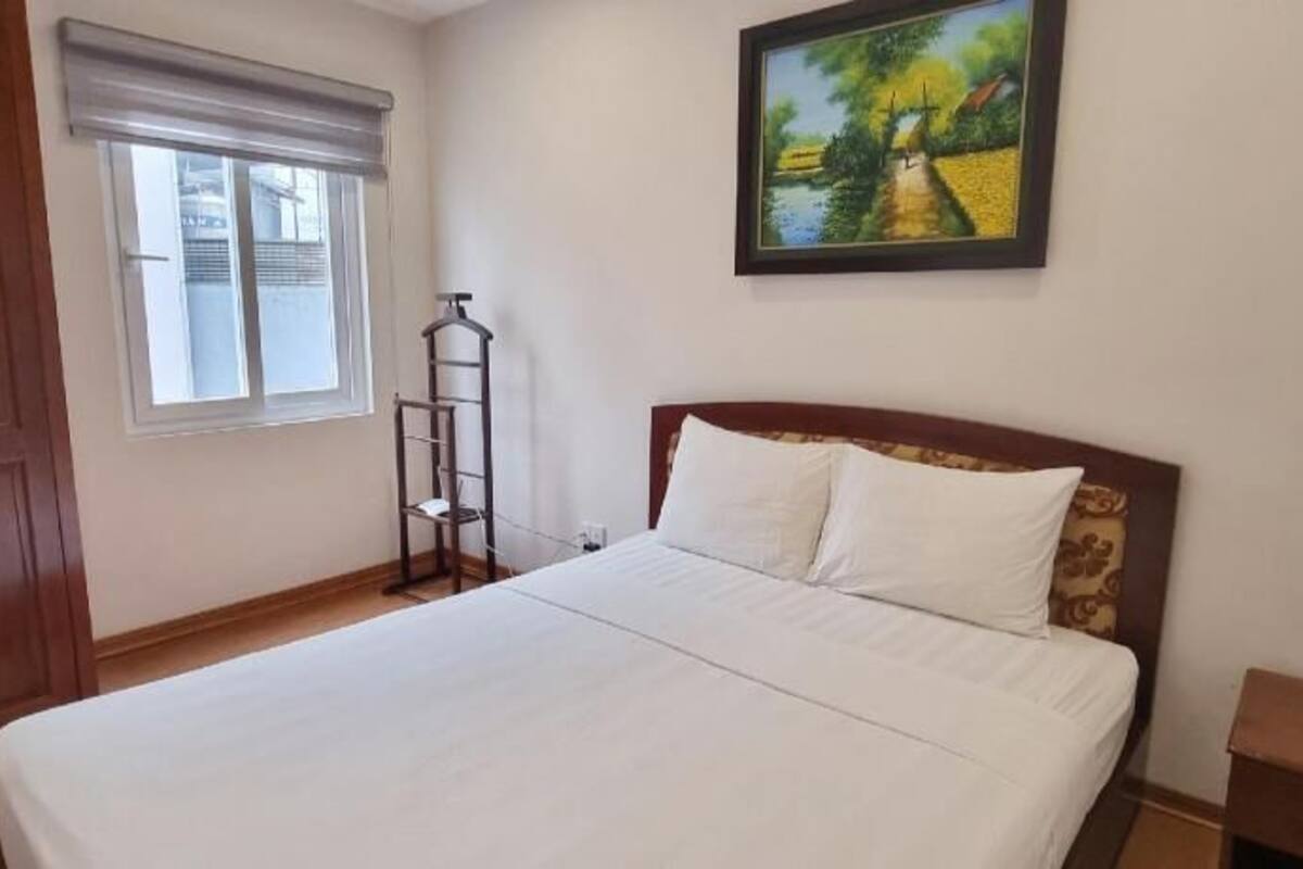 Une chambre à coucher avec un lit, une fenêtre, un tableau et une armoire.
