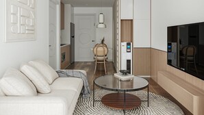 A modern living room with a sofa, a round coffee table, and a television.