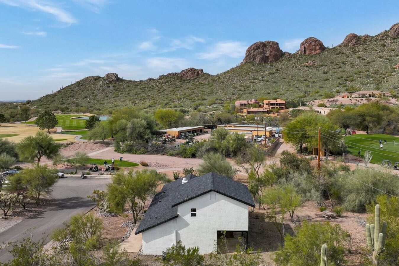 A residential area with houses, a golf course, and a mountainous backdrop.