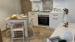 A modern kitchen with white cabinetry, a built-in oven, and a stainless steel range hood. - Piccola casetta, appena ristrutturata, un vero gioiellino, tra le vie del borgo. (Castellammare del Golfo)