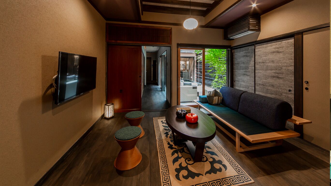 Un intérieur moderne avec un canapé, une petite table et un téléviseur fixé au mur.