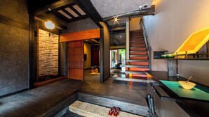 A modern interior with a staircase, wooden flooring, and a stone wall.