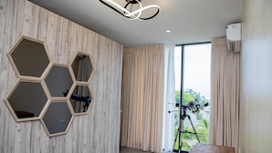A modern room with hexagonal mirrors on the wall, a tripod with a camera, and a large window with curtains. - CASA BIANCA (Accra)