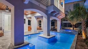 A swimming pool with a modern architectural design, including arched columns and a covered area with seating. - 4BR New Luxury Build with Huge Private Pool + Sunset Tower Views | Esmeralda (Destin)