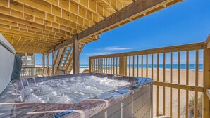 A wooden deck with a hot tub overlooking a beach. - Oceanfront Dog Friendly Home with Hot Tub, Game Room, and Direct Beach Access (Avon)