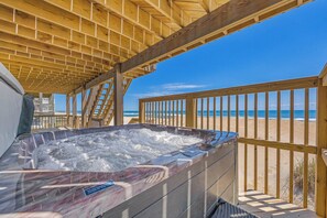 A wooden deck with a hot tub overlooking a beach. - Oceanfront Dog Friendly Home with Hot Tub, Game Room, and Direct Beach Access (Avon)