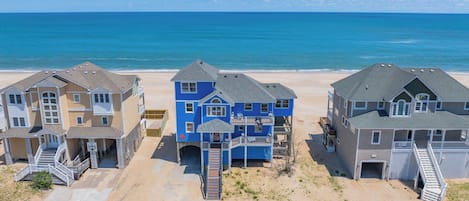 A beachfront property with multiple houses, a sandy beach, and the ocean in the background.