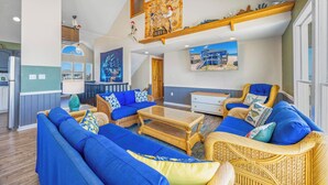 A spacious living area with a high ceiling, a dining area, and a kitchen. - Oceanfront Dog Friendly Home with Hot Tub, Game Room, and Direct Beach Access (Avon)