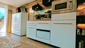 Eine moderne Küche mit weißen Schränken, einem eingebauten Backofen, einer Mikrowelle und einer Holz Arbeitsplatte.