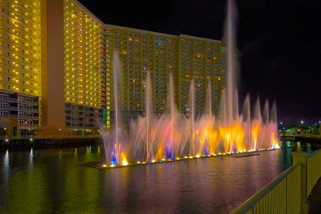 A hotel with a water fountain display in front of it.