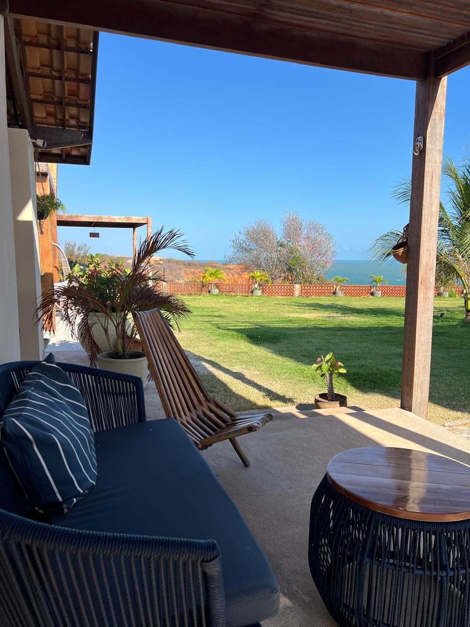 An outdoor seating area with a view of a grassy landscape and a body of water.