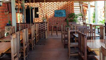 A restaurant with a brick wall, wooden tables and chairs, and a sign reading 'IN MARE BISTRO'.