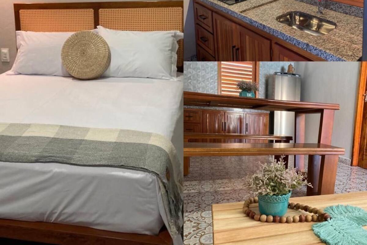 A bedroom with a bed, a bedside table with a plant, and a wall-mounted sign.