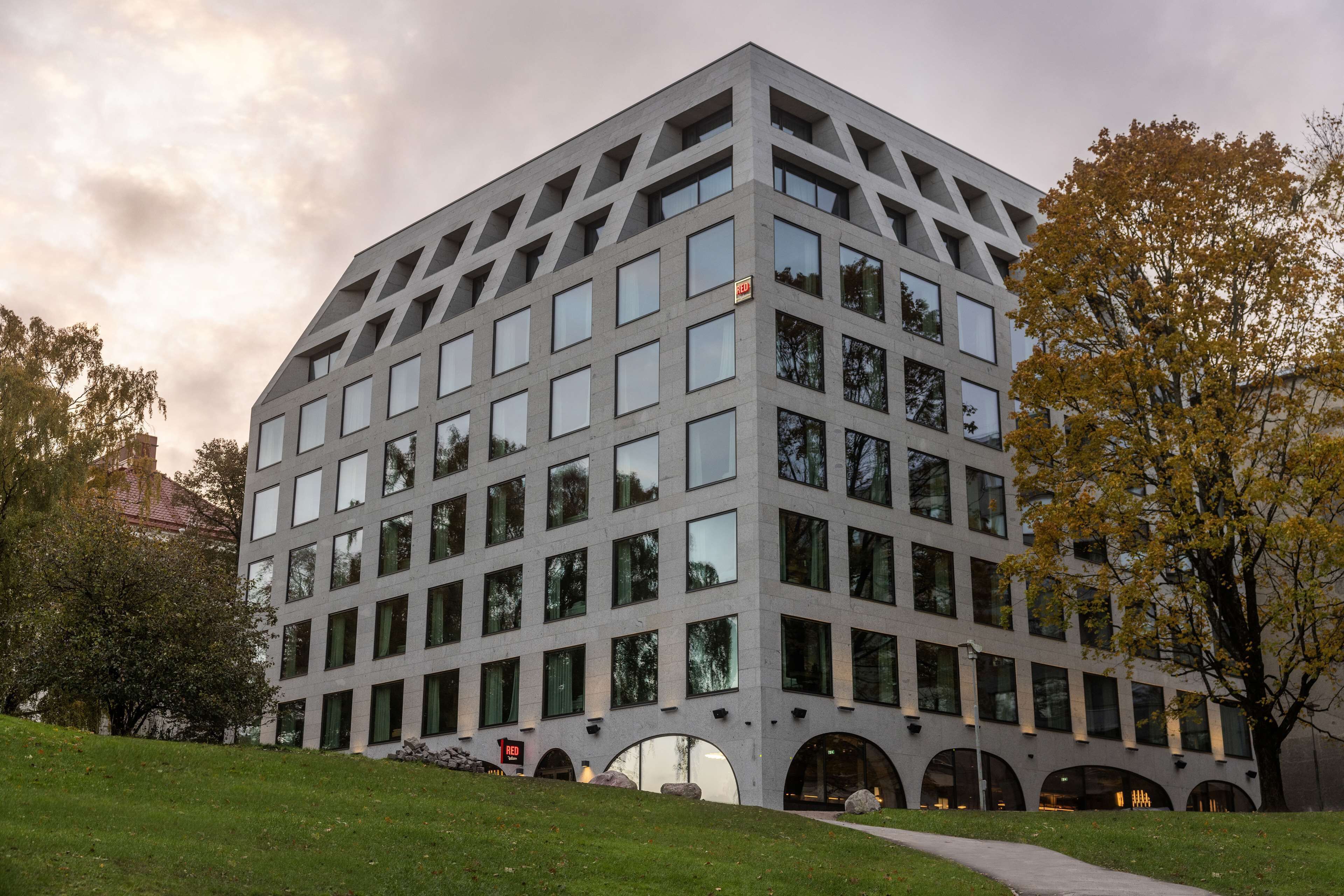 Un edificio moderno con una fachada de ventanas en forma de cuadrícula y un techo plano.