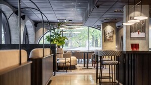 Un interior moderno con techo curvo, zona de estar y un ventanal con vistas a árboles.