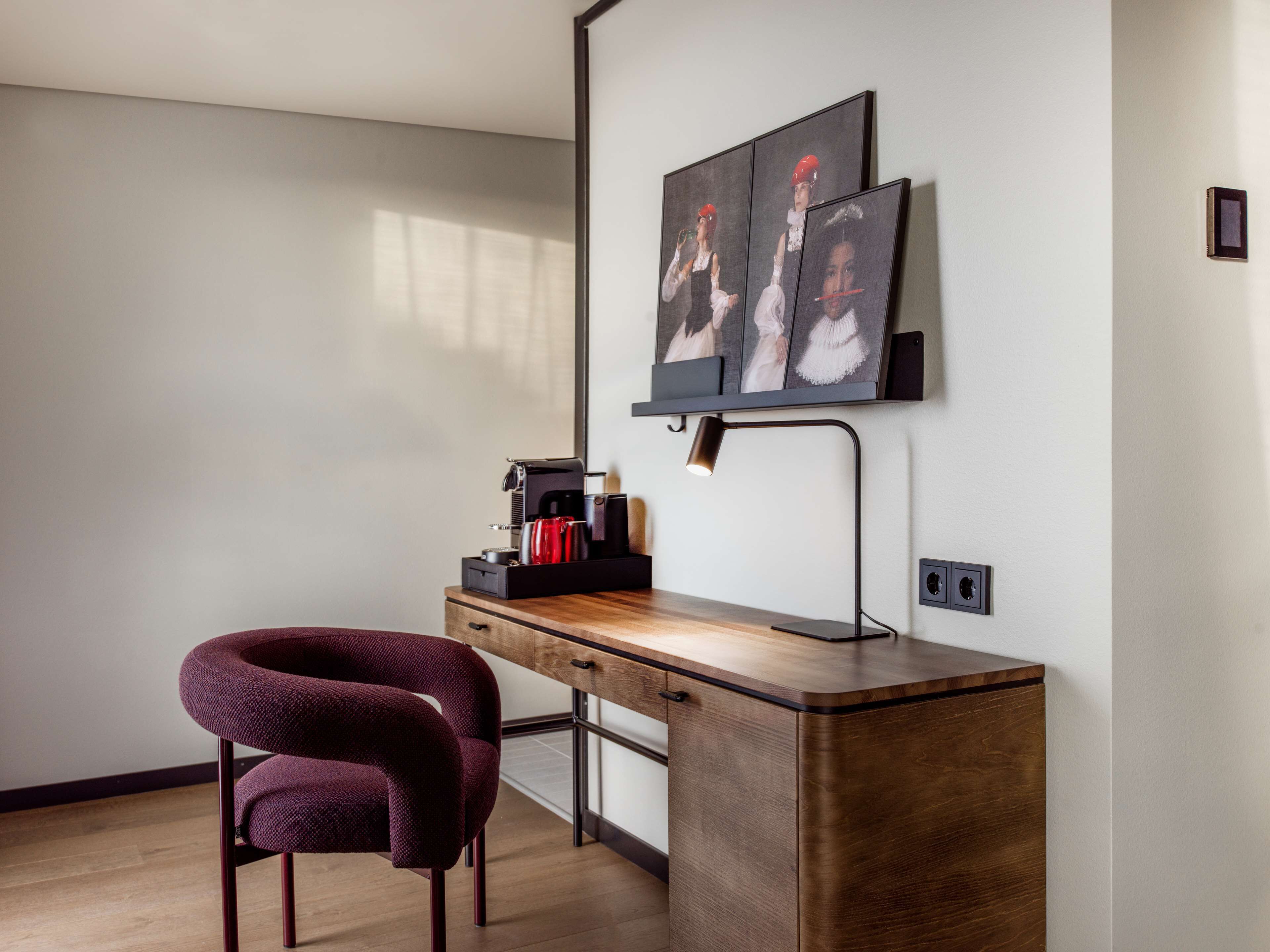 Un espace de travail moderne avec un bureau en bois, une chaise violette et une machine à café.
