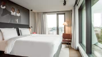 Quarto de hotel moderno com uma cama grande, vista para a cidade e decoração minimalista.