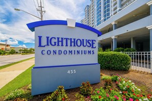 Une enseigne pour les copropriétés Lighthouse, offrant une vue dégagée sur l’entrée de l’immeuble et sur les aménagements paysagers environnants.