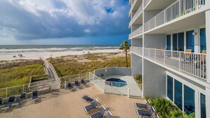Un hotel frente a la playa con piscina, tumbonas y vistas al océano.
