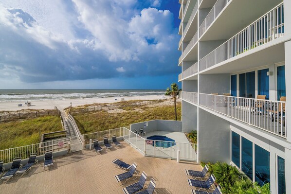 A beachfront hotel with a pool, sun loungers, and a view of the ocean. - 3BD Condo @ The Lighthouse 215 (Gulf Shores)